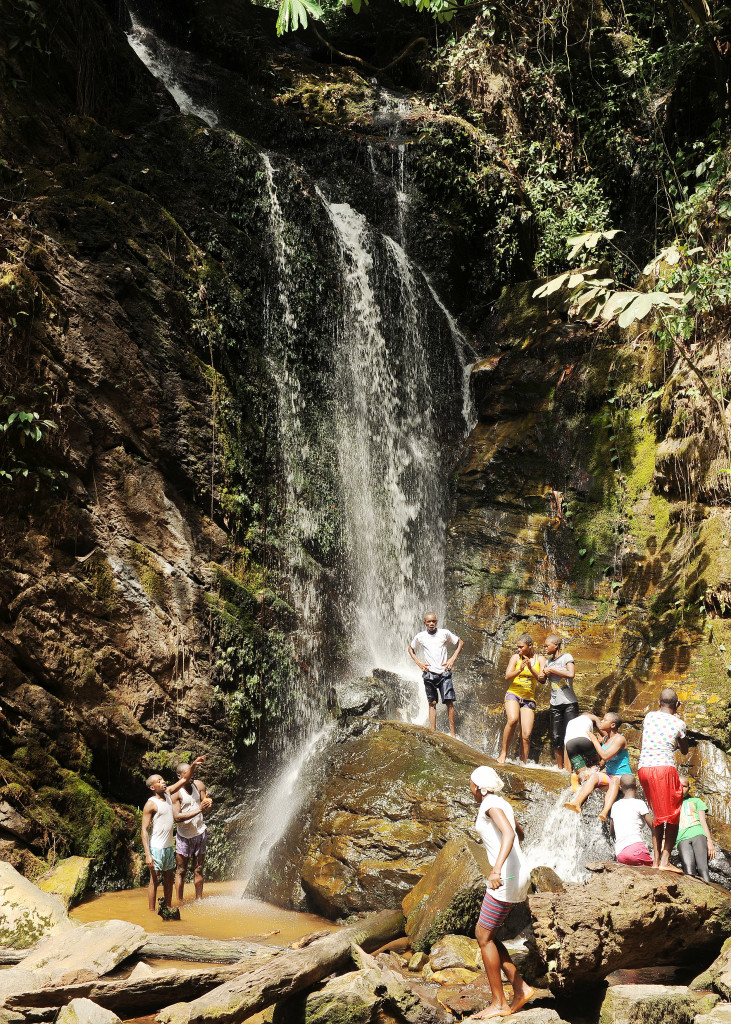 Visitors pausing among the rocks beside one of Olumirin's cascades
